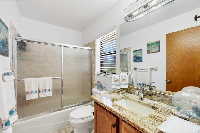 bathroom with bath / shower combo with glass door, toilet, and vanity