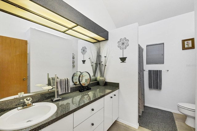 bathroom featuring vanity, toilet, and baseboards