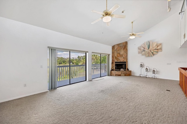 unfurnished living room with a stone fireplace, carpet flooring, high vaulted ceiling, and a ceiling fan