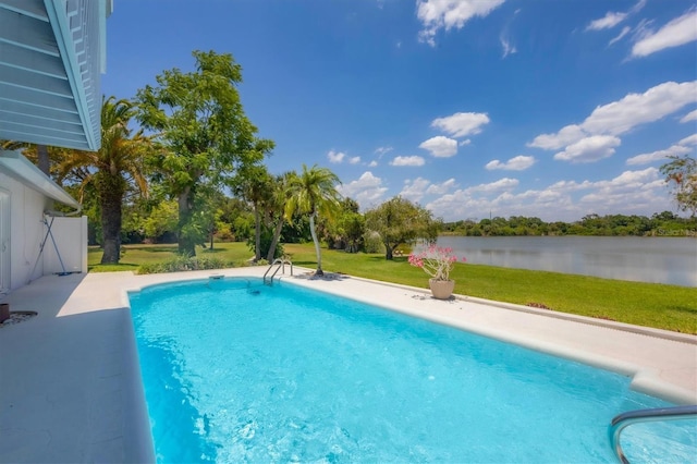 outdoor pool featuring a water view and a lawn