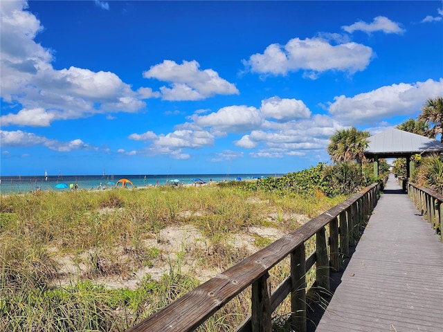 dock area featuring a gazebo, a water view, and a beach view