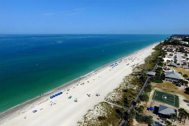 bird's eye view featuring a water view and a beach view