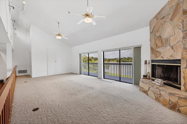 unfurnished living room with visible vents, ceiling fan, carpet flooring, a stone fireplace, and high vaulted ceiling