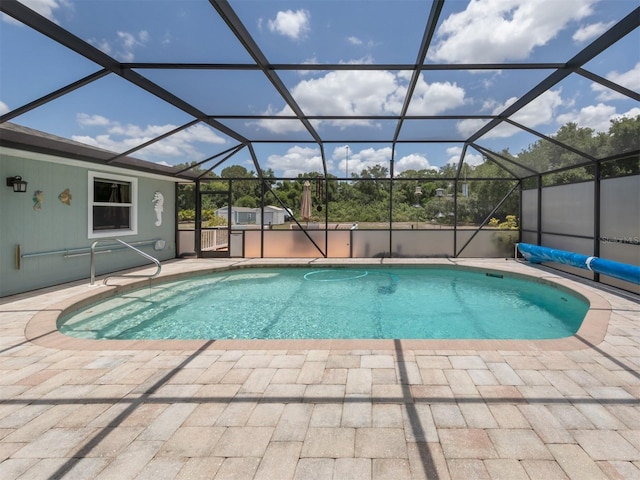 view of swimming pool with a patio area and a lanai