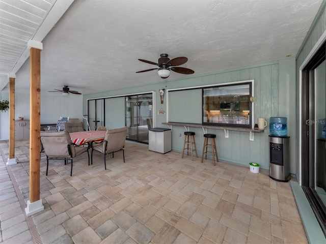 view of patio / terrace featuring ceiling fan and a bar