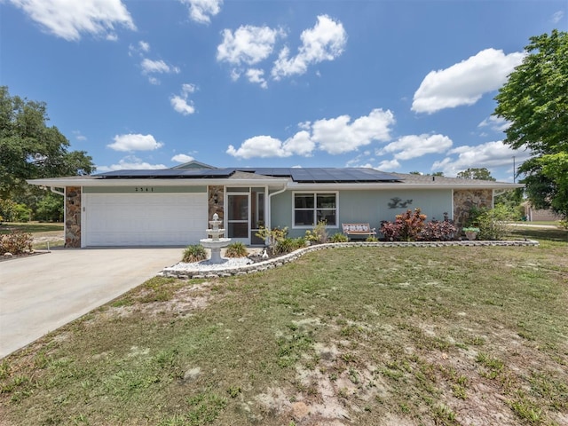 ranch-style house featuring solar panels, a garage, and a front lawn