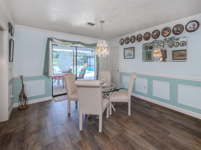 dining room with an inviting chandelier, dark wood-type flooring, and ornamental molding