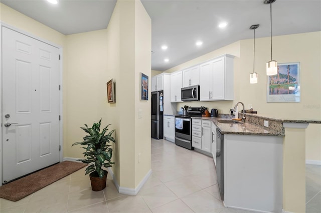 kitchen featuring white cabinets, appliances with stainless steel finishes, dark stone counters, sink, and kitchen peninsula