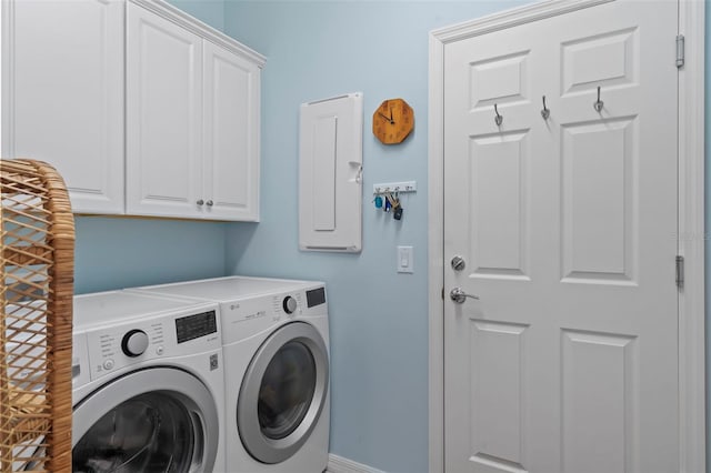 clothes washing area featuring washer and dryer and cabinets