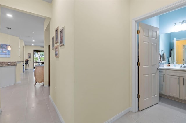 hall with light tile patterned flooring and sink