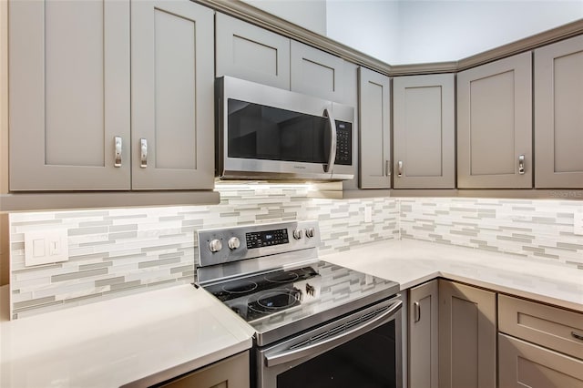 kitchen with backsplash, gray cabinetry, and stainless steel appliances