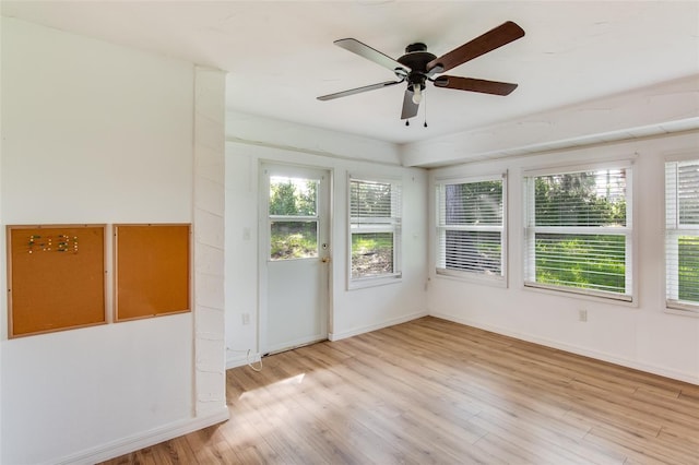 unfurnished sunroom with ceiling fan