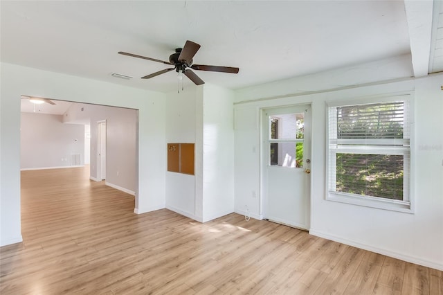 spare room featuring ceiling fan, a healthy amount of sunlight, and light hardwood / wood-style flooring