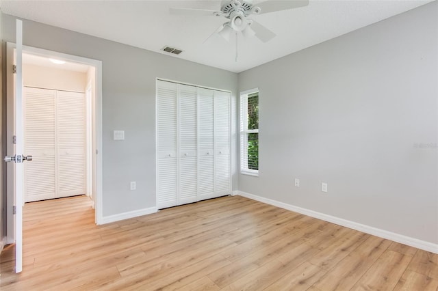 unfurnished bedroom featuring ceiling fan, light wood-type flooring, and a closet