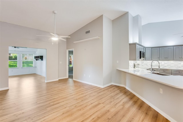 interior space featuring light wood-type flooring, high vaulted ceiling, and sink