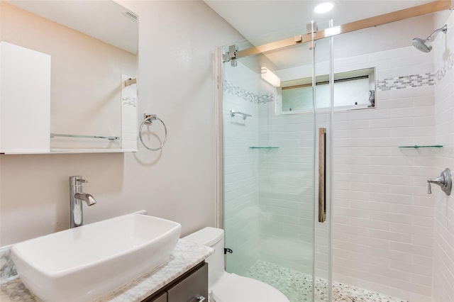 bathroom featuring walk in shower, vanity, and toilet