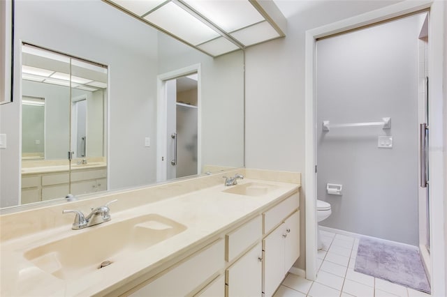 bathroom with toilet, vanity, and tile patterned floors