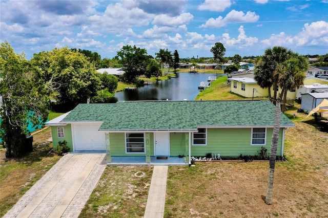 single story home featuring a front yard, a water view, and a garage