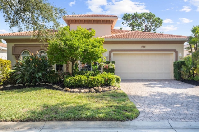 mediterranean / spanish home with stucco siding, a tile roof, decorative driveway, and a garage
