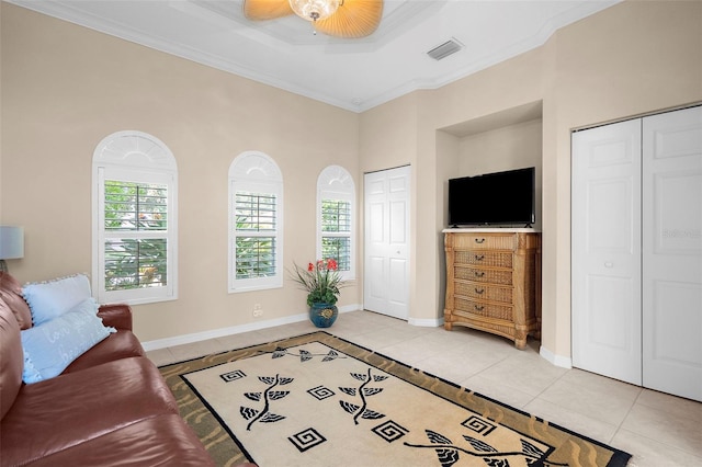 living room featuring ceiling fan, light tile patterned floors, and crown molding