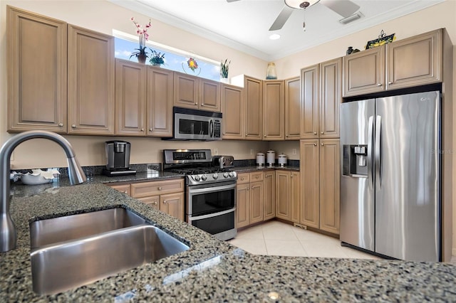 kitchen with ornamental molding, sink, appliances with stainless steel finishes, and dark stone counters