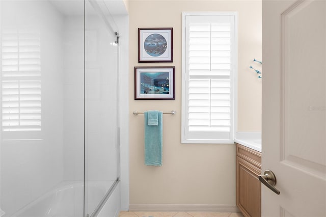 bathroom featuring tile patterned flooring, vanity, and combined bath / shower with glass door