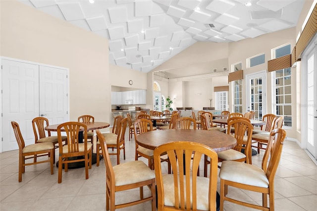 dining room featuring light tile patterned floors and high vaulted ceiling