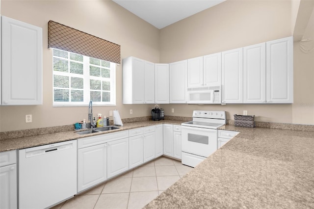 kitchen with white cabinets, white appliances, sink, and light tile patterned floors