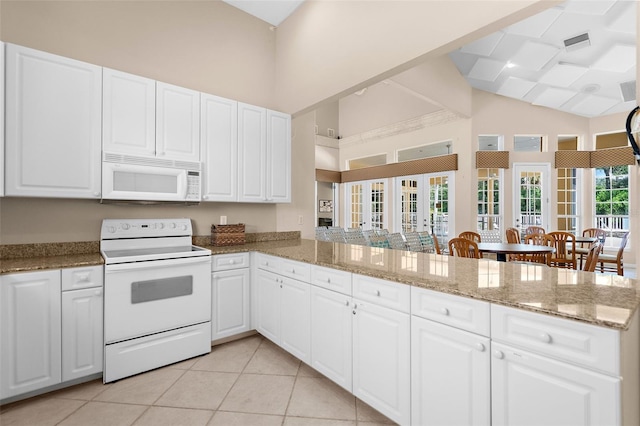 kitchen with white cabinets, white appliances, and kitchen peninsula