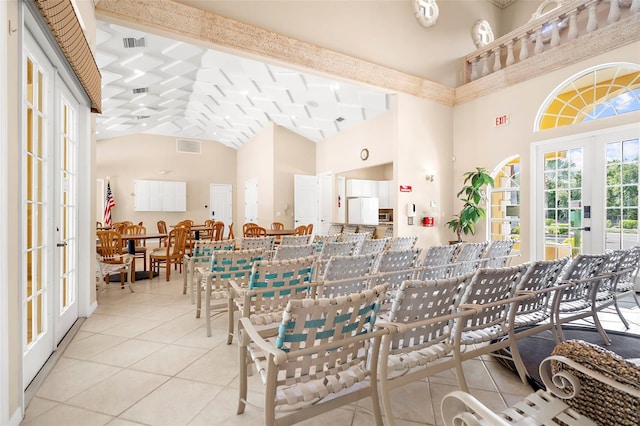 tiled dining space with beamed ceiling, high vaulted ceiling, and french doors