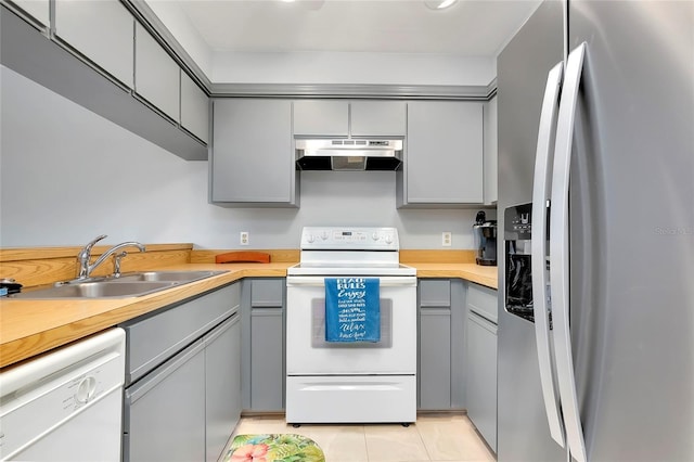 kitchen with light tile patterned floors, white appliances, gray cabinets, and sink