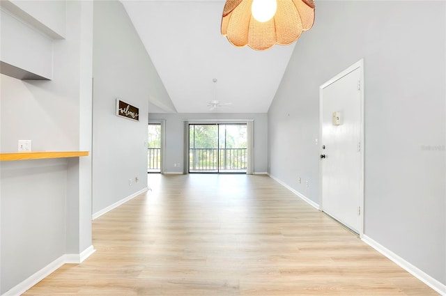 unfurnished living room with light wood-type flooring, high vaulted ceiling, and ceiling fan