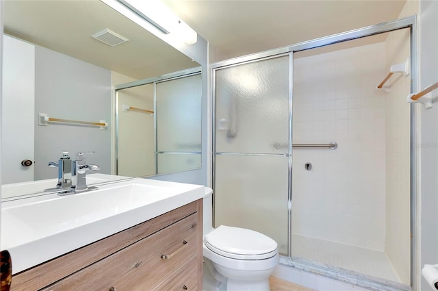 bathroom with an enclosed shower, vanity, and toilet