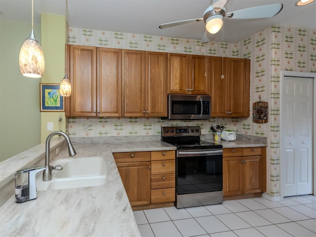 kitchen featuring stainless steel appliances, ceiling fan, sink, hanging light fixtures, and light tile patterned flooring