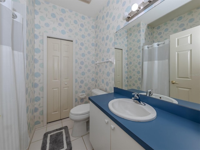 bathroom with tile patterned flooring, vanity, and toilet