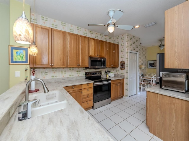 kitchen with sink, hanging light fixtures, ceiling fan, light tile patterned floors, and appliances with stainless steel finishes