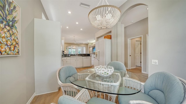 dining room with light wood finished floors, baseboards, visible vents, an inviting chandelier, and recessed lighting