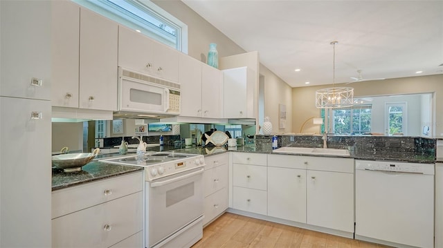 kitchen with sink, light hardwood / wood-style flooring, hanging light fixtures, white appliances, and white cabinets