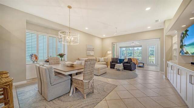 tiled dining space featuring ceiling fan with notable chandelier