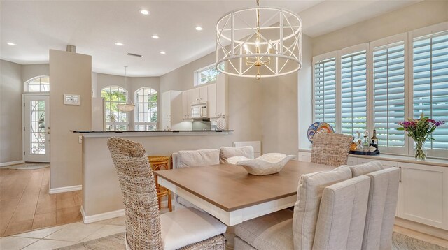 tiled dining room with a chandelier