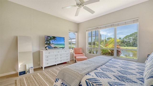 bedroom featuring ceiling fan, baseboards, and wood finished floors