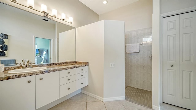 bathroom with vanity, tile patterned flooring, and a tile shower