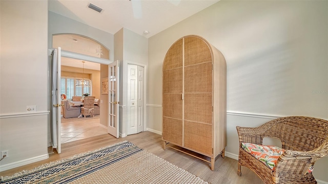 interior space with light wood-type flooring, french doors, visible vents, and baseboards