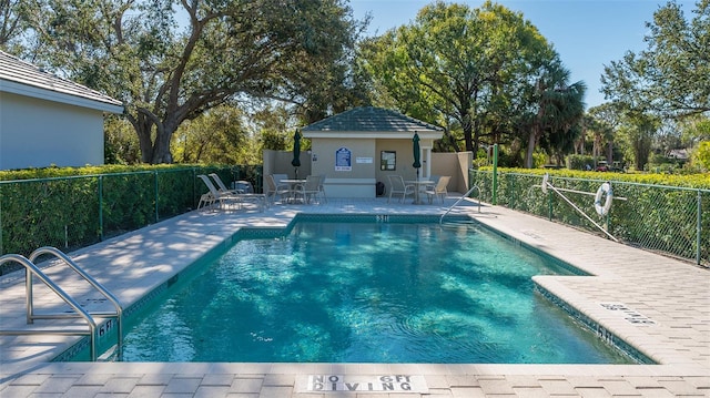 view of swimming pool with an outbuilding and a patio area