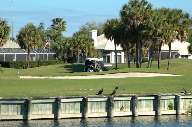 view of property's community with a lawn and a water view