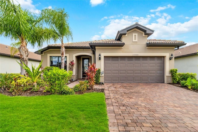 mediterranean / spanish house with a garage and a front lawn