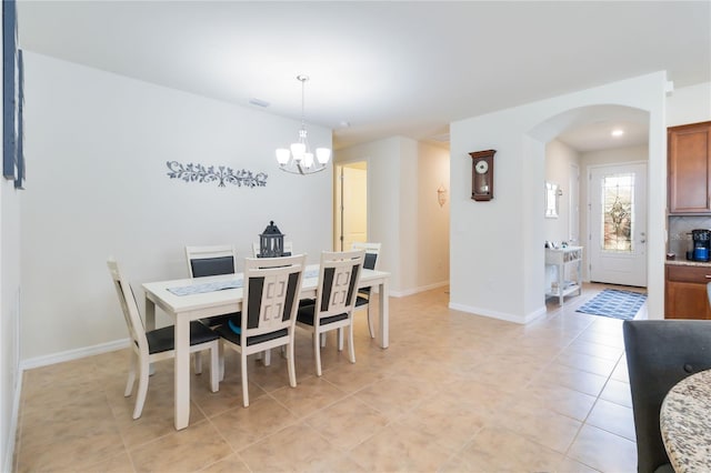 dining room with light tile patterned floors and a chandelier