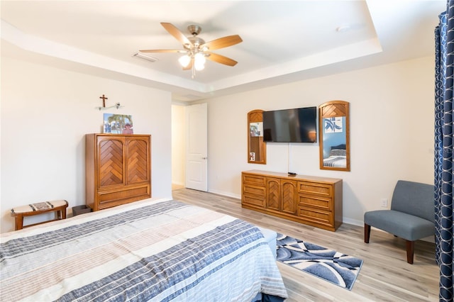 bedroom featuring a tray ceiling, light hardwood / wood-style flooring, and ceiling fan