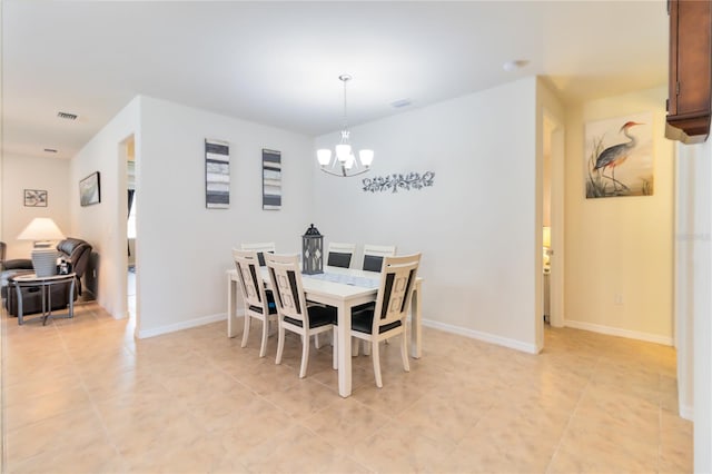 tiled dining room with an inviting chandelier