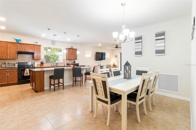 dining room featuring sink, ceiling fan with notable chandelier, and light tile patterned flooring